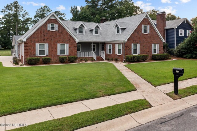 cape cod home with covered porch and a front yard