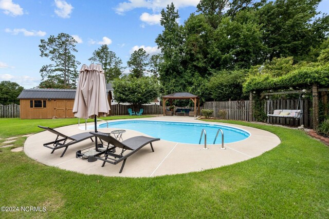 view of pool with a lawn, a patio, an outdoor structure, and a gazebo