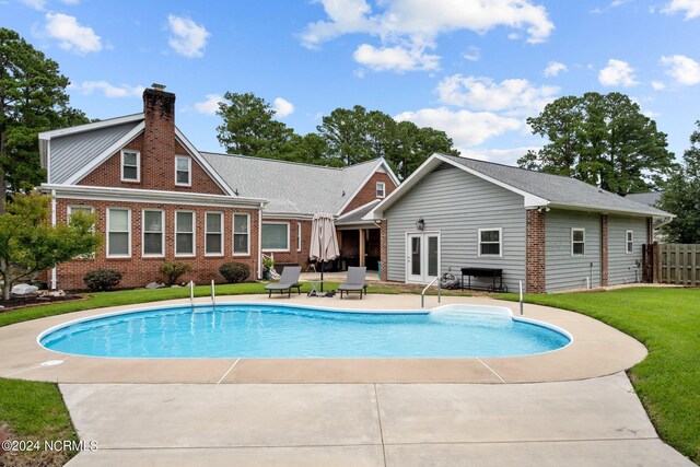 view of pool featuring a fenced in pool, a patio area, a lawn, and fence