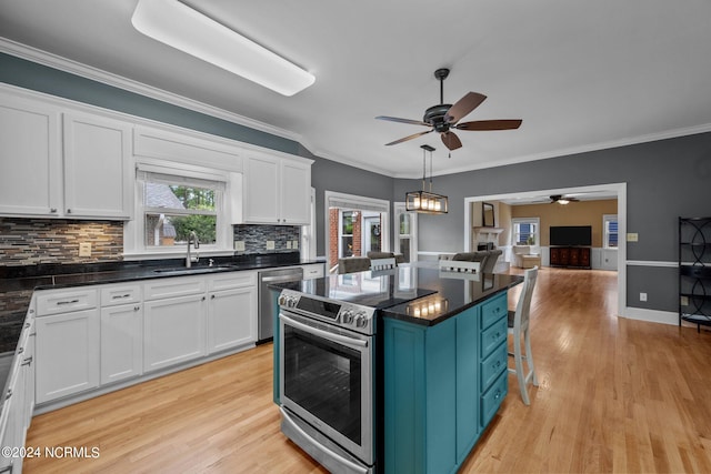 kitchen featuring ceiling fan with notable chandelier, appliances with stainless steel finishes, light hardwood / wood-style floors, white cabinets, and decorative backsplash