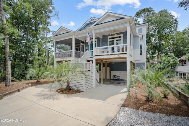 beach home with ceiling fan, covered porch, and a carport