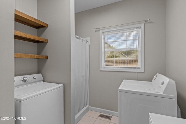 laundry area featuring light tile patterned flooring and washer and clothes dryer