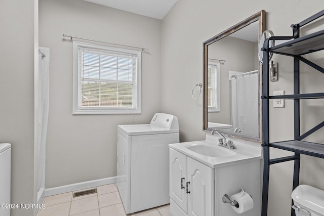 clothes washing area with washer / clothes dryer, light tile patterned flooring, and sink