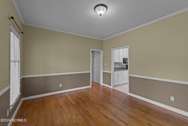 unfurnished bedroom with ornamental molding, a closet, and light hardwood / wood-style floors