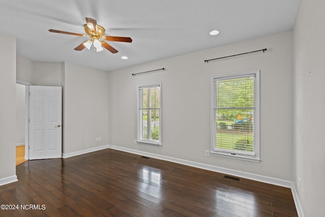 empty room with ceiling fan, hardwood / wood-style flooring, and a wealth of natural light