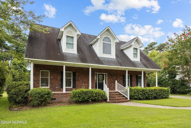 new england style home featuring a porch and a front yard