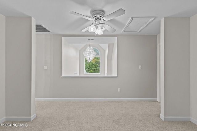 spare room featuring ceiling fan with notable chandelier and light carpet