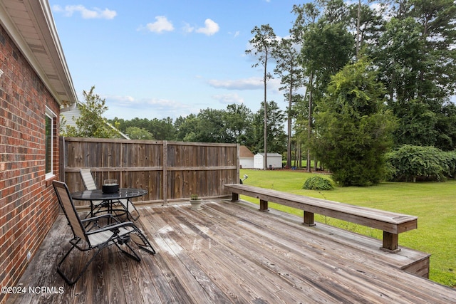 wooden deck featuring a lawn