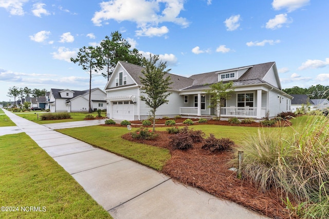 view of front of property with driveway, a porch, a standing seam roof, and a front yard