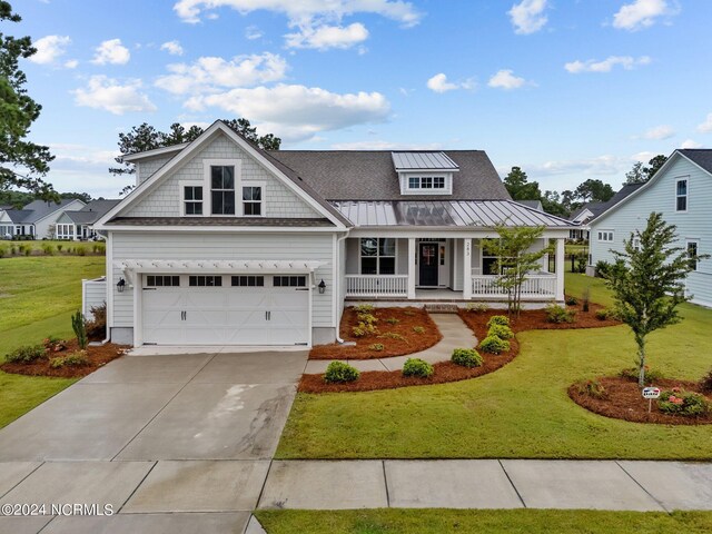 view of front facade featuring a front yard, a garage, and a porch