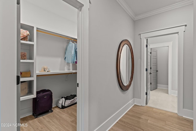 hallway featuring crown molding, baseboards, and wood finished floors