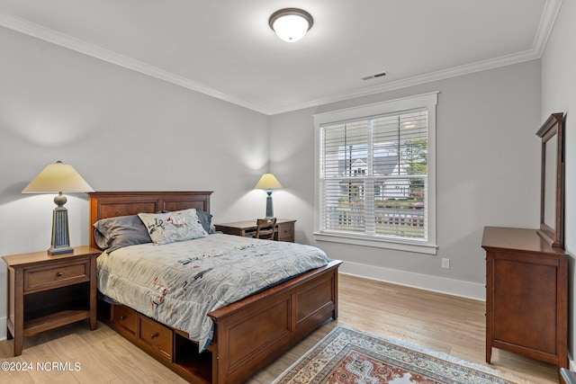 bedroom with crown molding, light wood-type flooring, visible vents, and baseboards