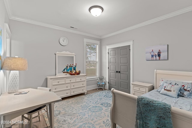 bedroom featuring baseboards, crown molding, visible vents, and wood finished floors