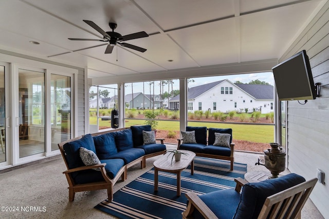 sunroom / solarium featuring a residential view and a ceiling fan