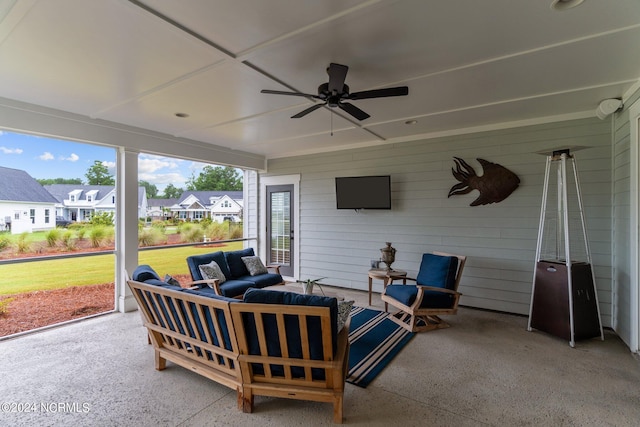 sunroom featuring plenty of natural light, a residential view, and a ceiling fan