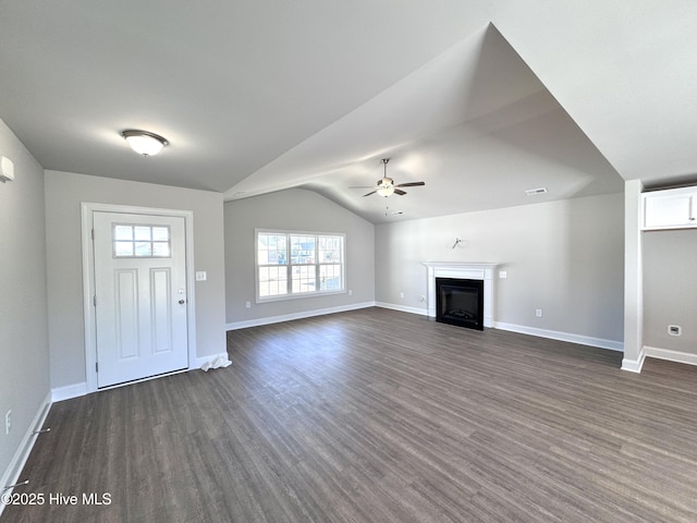 unfurnished living room featuring lofted ceiling, dark wood-style flooring, a fireplace, a ceiling fan, and baseboards