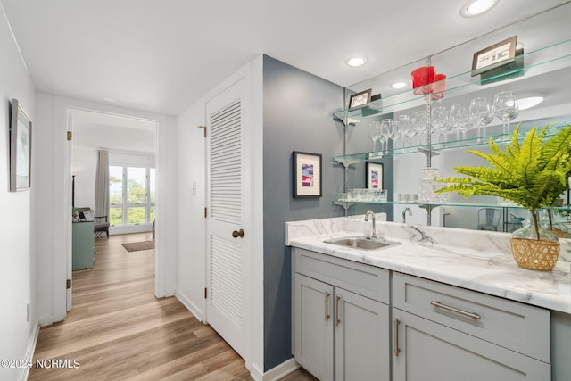 bathroom featuring baseboards, wood finished floors, vanity, a closet, and recessed lighting