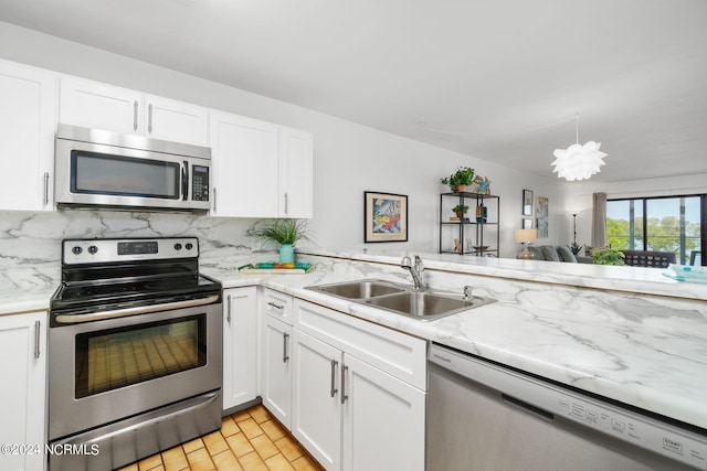 kitchen with tasteful backsplash, white cabinets, appliances with stainless steel finishes, light wood-style floors, and a sink