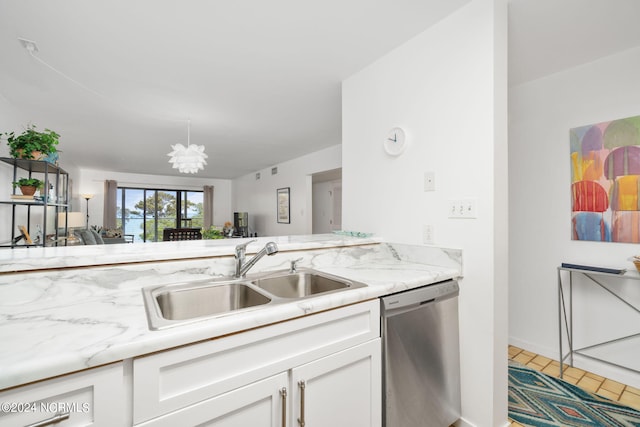 kitchen featuring white cabinets, dishwasher, light stone counters, a chandelier, and a sink