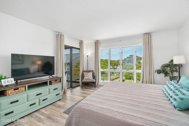 bedroom featuring light wood finished floors and access to outside