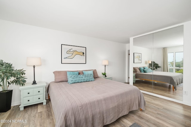 bedroom with light wood-style flooring and baseboards