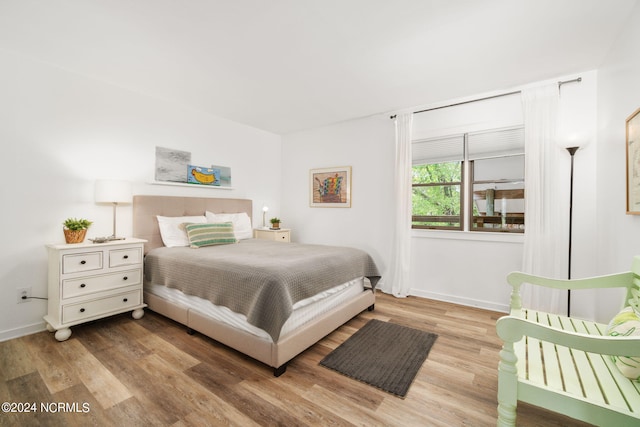 bedroom with baseboards and wood finished floors