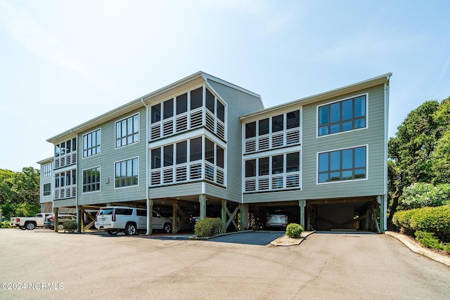 view of building exterior featuring a carport and driveway