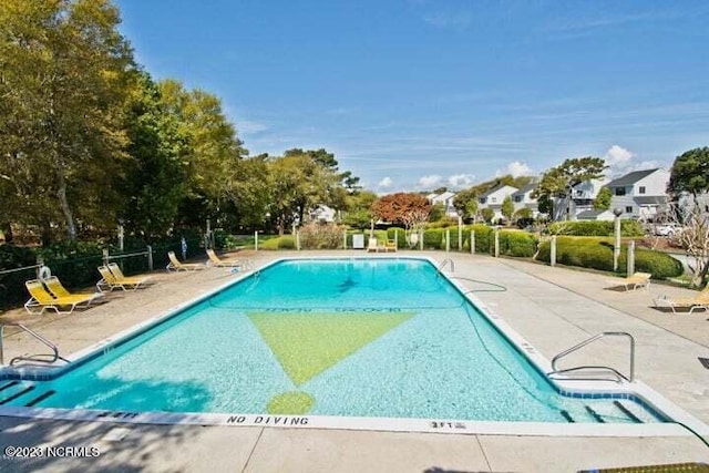 community pool featuring fence and a patio