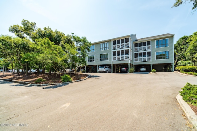 view of front facade featuring dirt driveway and a carport