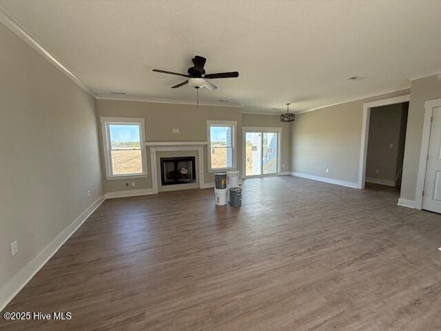 unfurnished living room with crown molding, a healthy amount of sunlight, and dark hardwood / wood-style floors