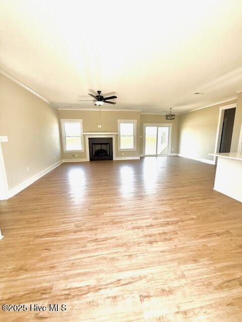 304 Old Swamp Rd, South Mills, NC 27976 - unfurnished living room featuring a ceiling fan, light wood-style flooring, healthy amount of natural light, ornamental molding, and baseboards