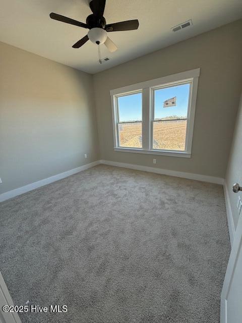 spare room featuring light colored carpet and ceiling fan