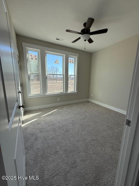 empty room with ceiling fan and carpet