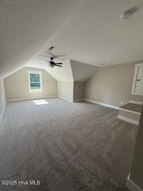 304 Old Swamp Rd, South Mills, NC 27976 - bonus room featuring a textured ceiling, lofted ceiling, baseboards, carpet, and a ceiling fan