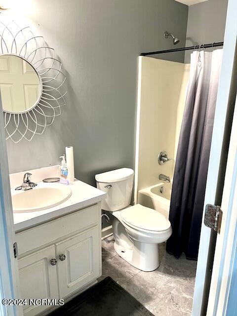 full bathroom featuring shower / bath combo with shower curtain, vanity, tile patterned flooring, and toilet