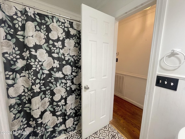 bathroom featuring crown molding and hardwood / wood-style flooring