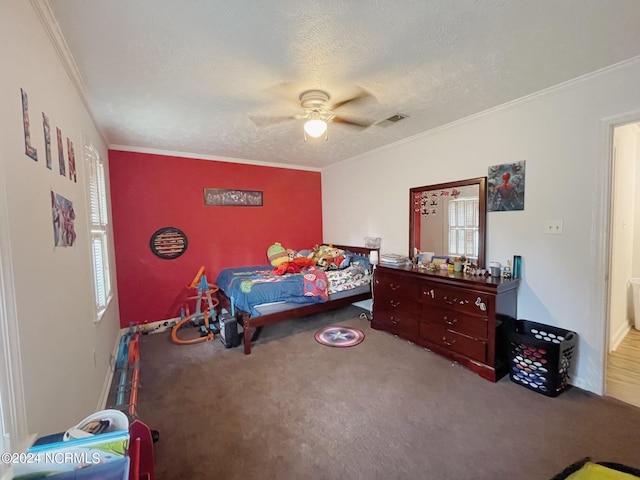 carpeted bedroom featuring ceiling fan, crown molding, and a textured ceiling