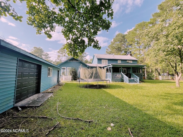 view of yard with a garage and a trampoline