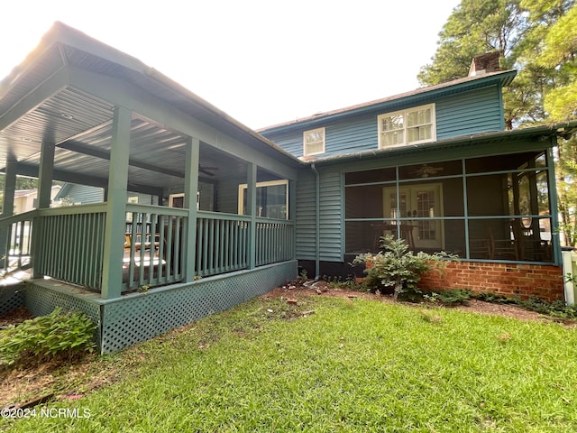 rear view of property with a sunroom and a lawn