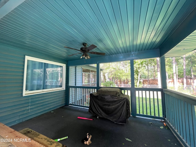 unfurnished sunroom with a wealth of natural light, ceiling fan, and wood ceiling