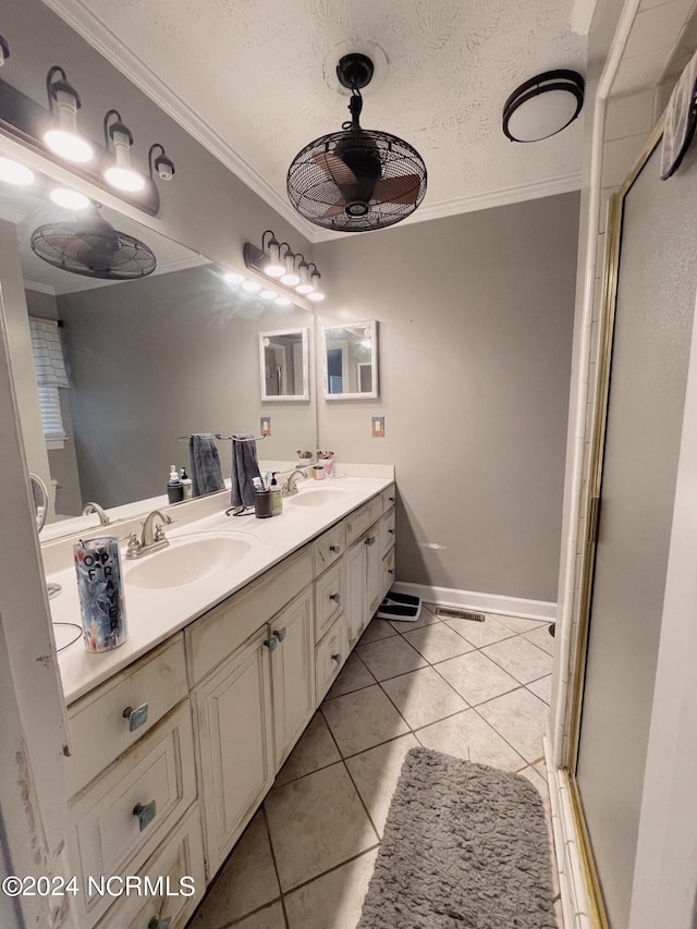 bathroom featuring dual vanity, ornamental molding, a textured ceiling, and tile patterned floors