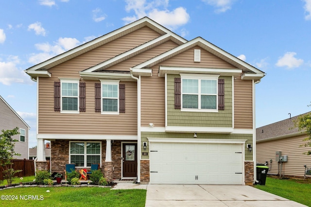 craftsman inspired home featuring a garage and a front lawn