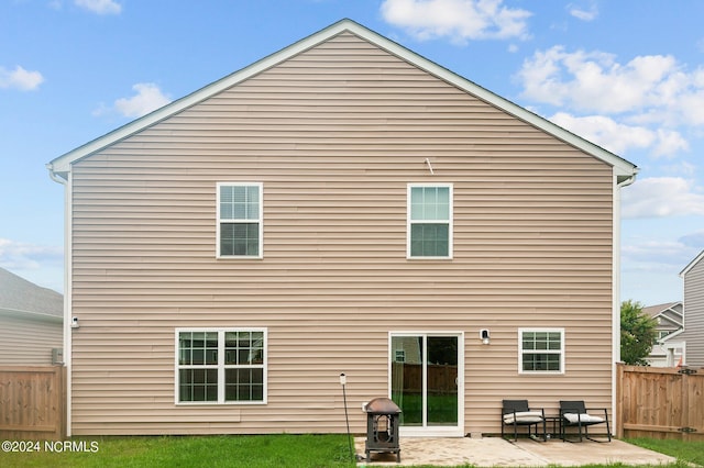 rear view of property featuring a patio area and fence