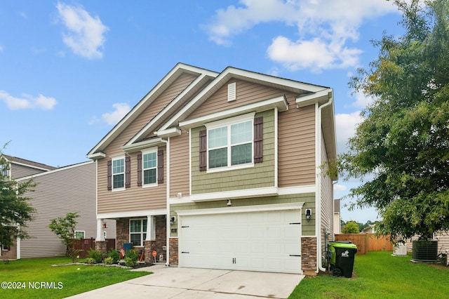 craftsman-style house with concrete driveway, an attached garage, a front yard, fence, and stone siding