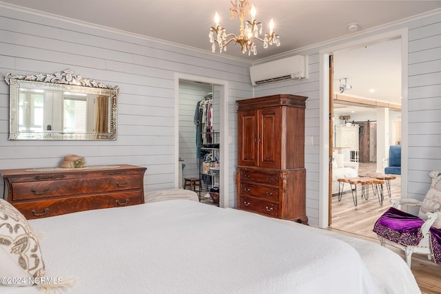 511 N A St, Bridgeton, NC 28519 - bedroom featuring ornamental molding, a wall unit AC, a spacious closet, wooden walls, and wood finished floors