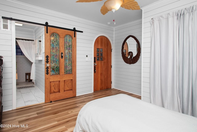511 N A St, Bridgeton, NC 28519 - bedroom featuring wooden walls, crown molding, a barn door, arched walkways, and ceiling fan