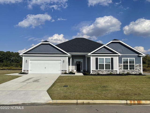 craftsman house featuring a garage, concrete driveway, stone siding, a front lawn, and board and batten siding