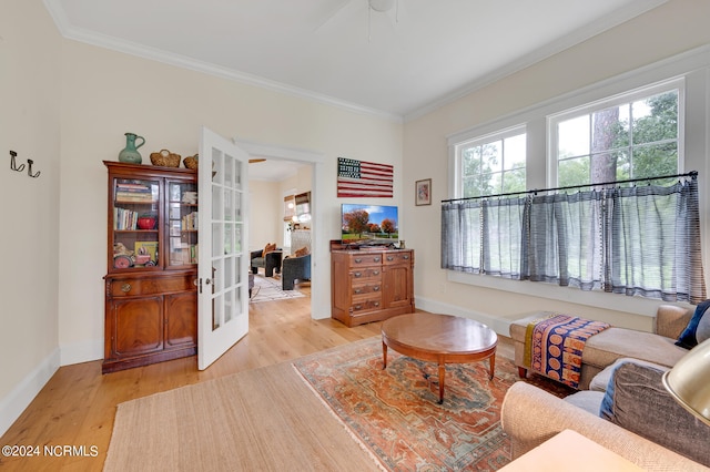 living room featuring french doors, ornamental molding, and light hardwood / wood-style flooring