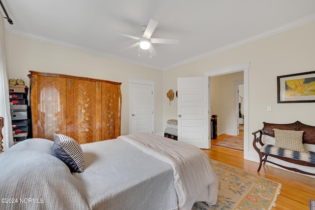 bedroom featuring crown molding, light hardwood / wood-style flooring, and ceiling fan