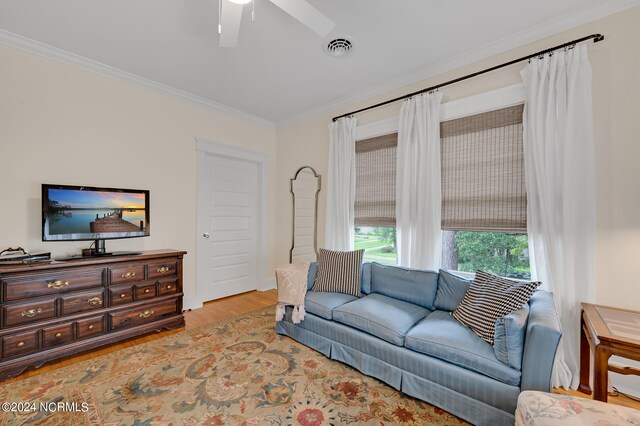 living room with crown molding, ceiling fan, and light hardwood / wood-style floors